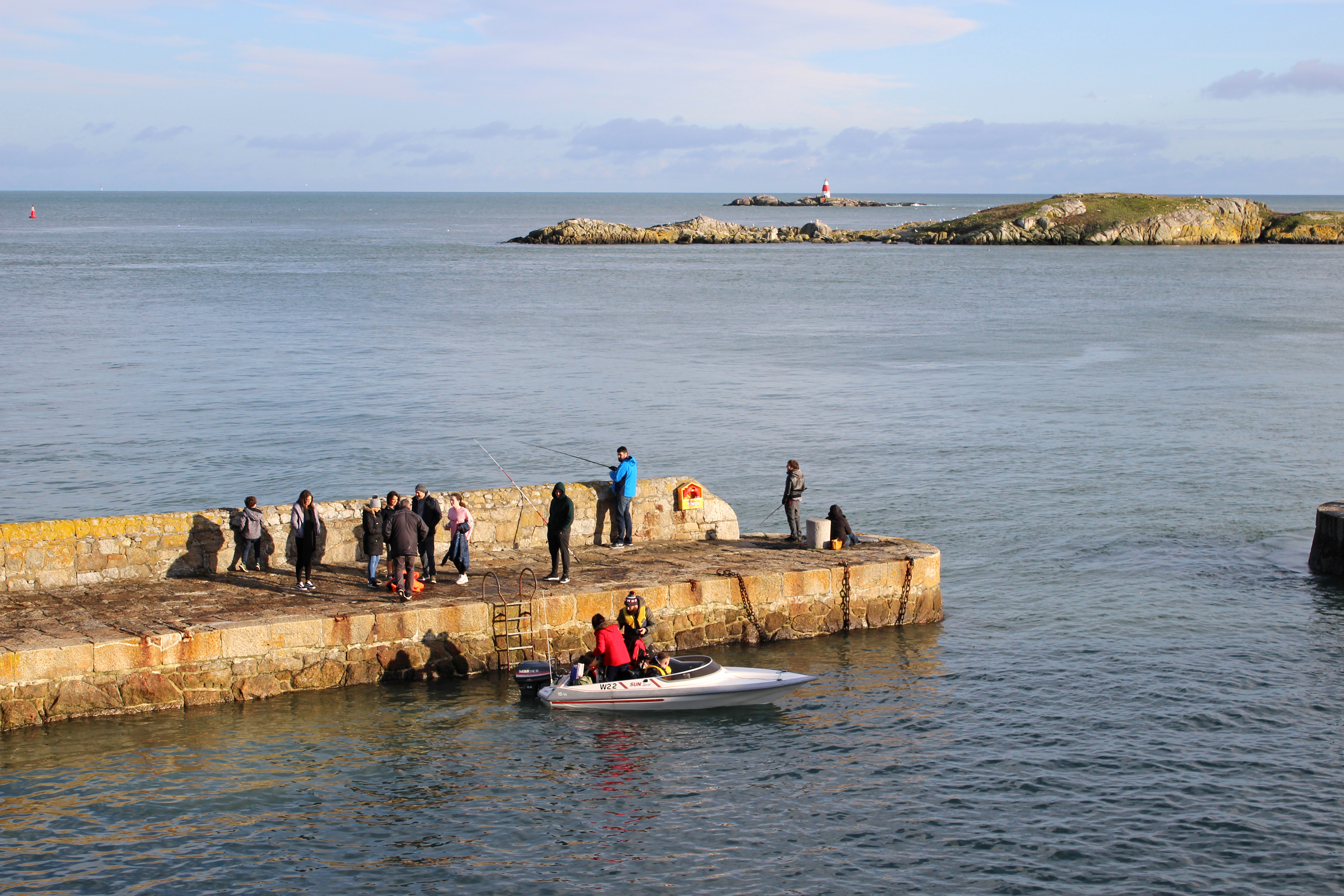 People on a pier with a boat 