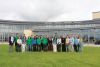 A group photo of bursars and supervisors on the background of the Marine Institute Headquarters